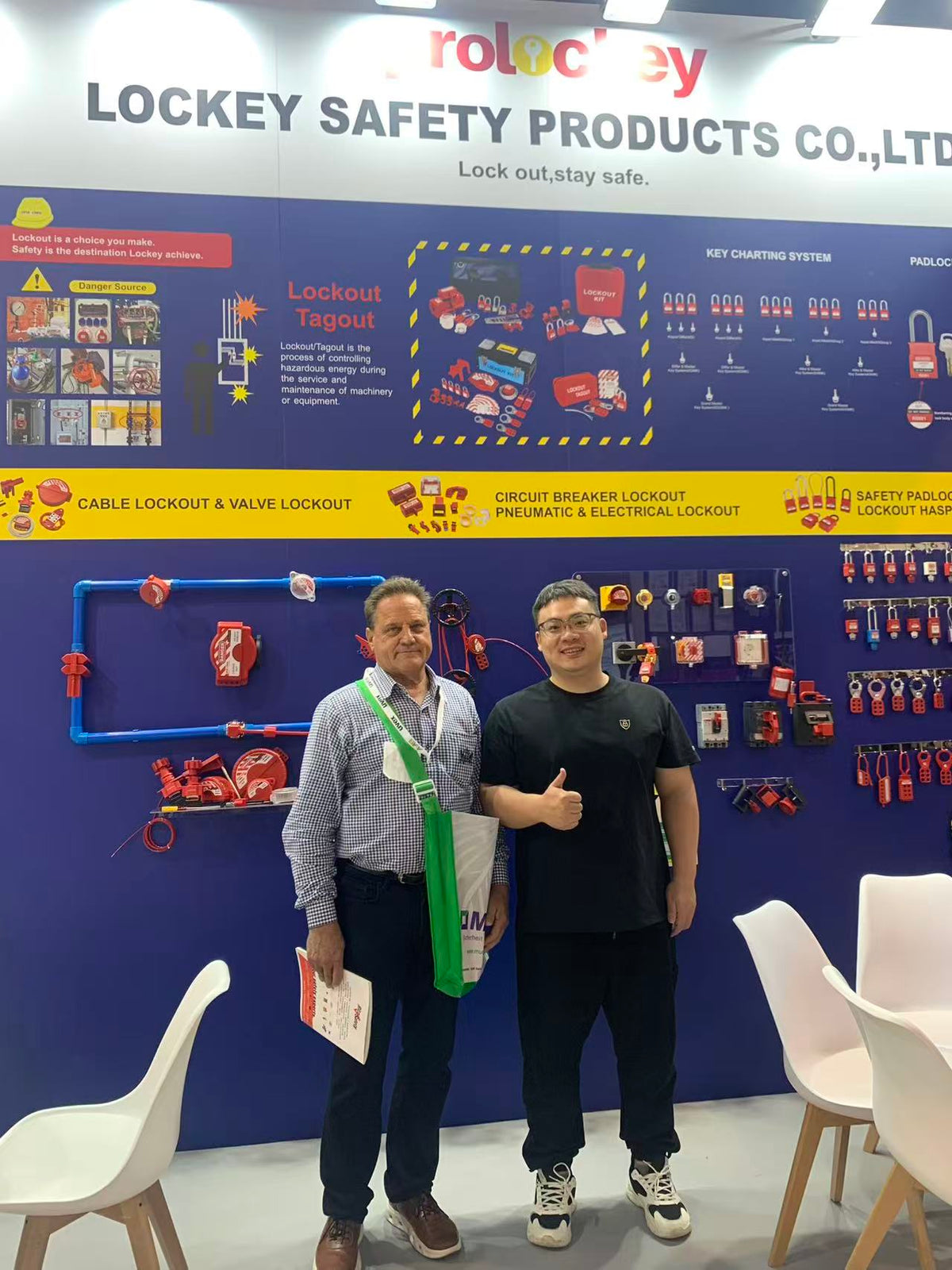 PROLOCKEY representative and visitor beside safety padlock and lockout displays at A+A 2025